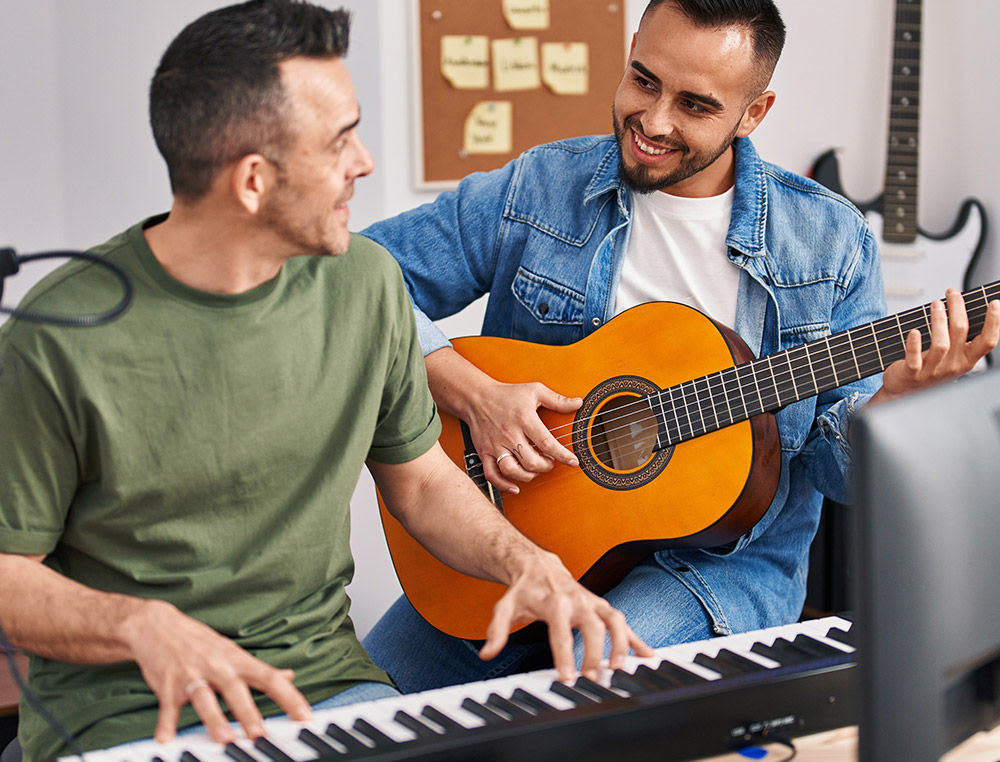 Two adults playing musical instruments, one piano and other guitar